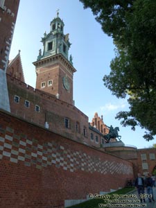 Фото Кракова. Вавель (Wawel). Стена с кирпичами с именами дарителей и Часовая башня (Wieza Zegarowa), вид со стороны подъезда к Гербовым воротам.